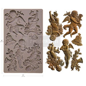 May include: A silicone mold featuring cherubic angel designs, measuring 8 inches (20.3 cm) by 5 inches (12.7 cm). The mold includes detailed relief images of angels with wings, flowers, and musical instruments. The angels are in various poses.