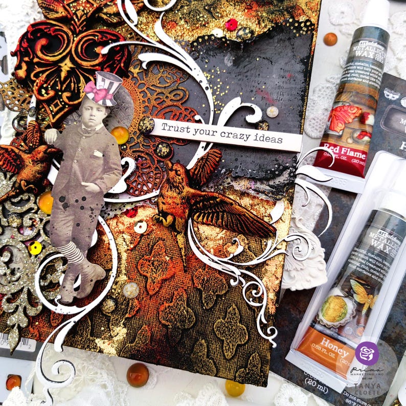 May include: A mixed media art piece with a vintage feel. The piece features a young boy in a top hat, a bird, and a quote that reads "Trust your crazy ideas". The piece is decorated with gold leaf, glitter, and other embellishments. The piece is framed with a white border.