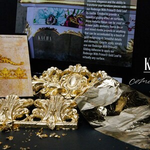 May include: Gold leaf furniture appliques and gilding flakes are displayed against a black background. The image includes the text "KACHA coming soon..." and product information about Redesign With Prima Gold Leaf.