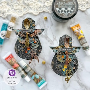 May include: Two black and gold decorative ornaments with wings, gears, and glitter. One ornament has a spoon with the text "be amazed" and the other has a fork with the text "take risks".