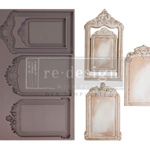 May include: A gray silicone mold with ornate rectangular and arched frame designs, alongside three finished decorative frames in cream and gold. The frames feature intricate floral and scrollwork details, with the text "re-design with prima" visible.