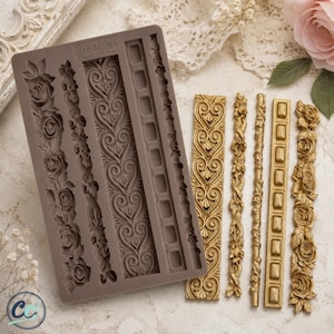 May include: A rectangular brown silicone mold featuring four distinct vertical decorative patterns, including roses, scrolling hearts, and geometric shapes, alongside four corresponding gold-colored cast pieces that match the mold's intricate designs.
