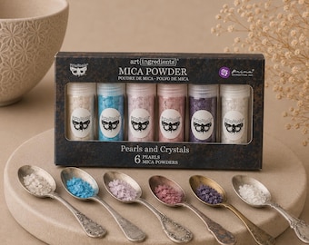 May include: A set of six Art Ingredients Mica Powder bottles labeled Pearls and Crystals, featuring a moth logo. The set includes white, blue, light pink, dark pink, purple, and iridescent powders, each displayed in a small metal spoon.