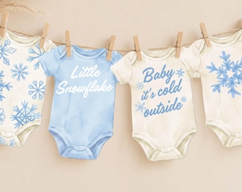 May include: Four baby bodysuits hanging on a clothesline with wooden clips. Two are cream with blue snowflake patterns, one is light blue with the white text Little Snowflake, and one is cream with the blue text Baby it's cold outside.