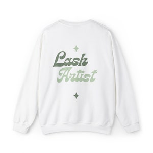May include: White sweatshirt with a green and white "Lash Artist" graphic on the back.