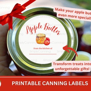 May include: A jar lid with an "Apple Butter" label, featuring a watercolor illustration of a jar and apples. The label includes the text "from the kitchen of Simply Canning". A red bow adorns the jar, with text that reads "Make your apple butter even more special!" and "Transform treats into unforgettable gifts!"