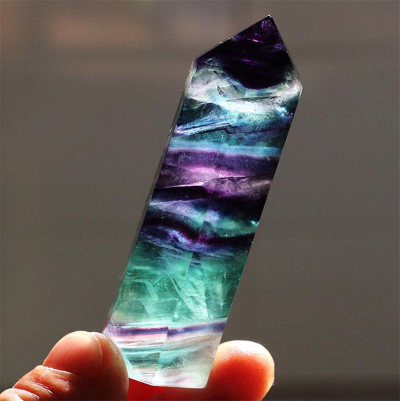 A multicolored Fluorite tower held up to the light, enhancing Aquarius energy with intellectual clarity and balance.