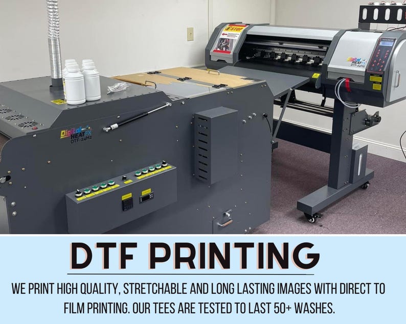 May include: A close-up of a DTF printing machine with a large printer and a heat press. The text "DTF PRINTING" is displayed in large, bold letters. The text "WE PRINT HIGH QUALITY, STRETCHABLE AND LONG LASTING IMAGES WITH DIRECT TO FILM PRINTING. OUR TEES ARE TESTED TO LAST 50+ WASHES." is displayed below the title.