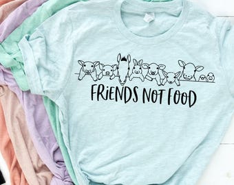 Könnte beinhalten: Ein hellblaues T-Shirt mit einer schwarzen Grafik von Nutztieren und dem Text "Friends Not Food".