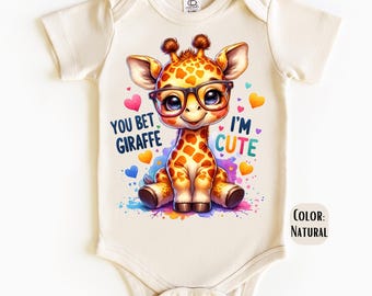 Peut inclure: Un body bébé couleur crème avec une girafe de dessin animé portant des lunettes. La girafe est entourée de cœurs colorés et d'éclaboussures de peinture. Le texte "You bet giraffe" et "I'm cute" est imprimé sur le body.