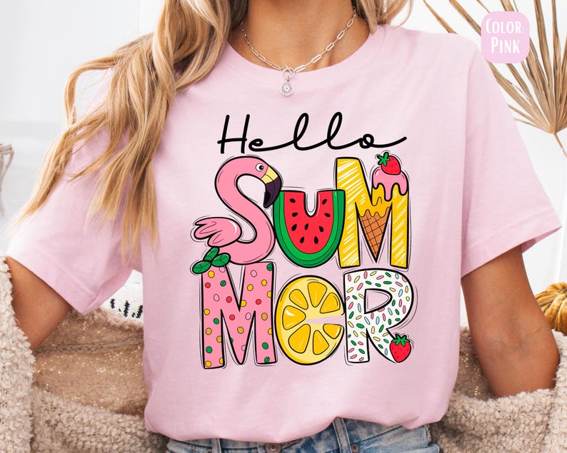 May include: Pink t-shirt with the text "Hello Summer" in colorful letters. The letters are decorated with a flamingo, watermelon, ice cream cone, lemon, and sprinkles.