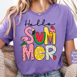 May include: Purple t-shirt with the text "Hello Summer" in colorful letters. The letters are decorated with a flamingo, watermelon, ice cream cone, lemon, and sprinkles.