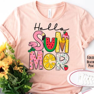 May include: A pink t-shirt with the text "Hello Summer" in colorful letters. The letters are decorated with images of a flamingo, watermelon, ice cream cone, lemon, and strawberries.