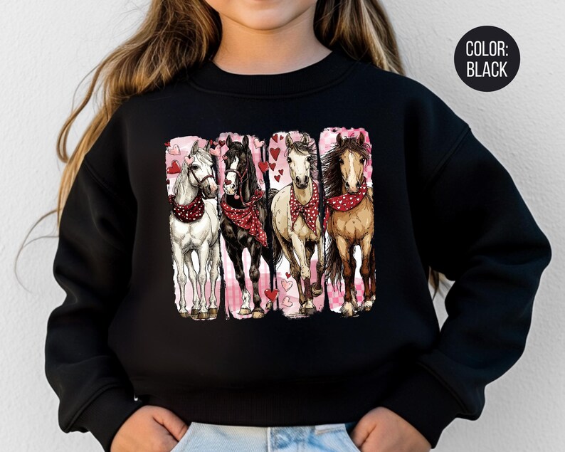 May include: Black sweatshirt with a graphic of four horses wearing red bandanas and surrounded by hearts. The horses are white, black, tan, and brown. The background is pink. The text "COLOR: BLACK" is in a black circle.