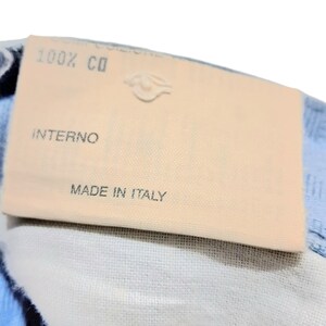 May include: A close-up of a beige fabric label with the text "100% CO", "INTERNO", and "MADE IN ITALY".