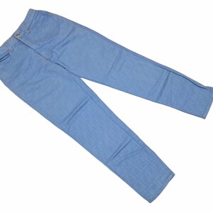 May include: A pair of light blue denim jeans. The jeans are laid flat on a white background.