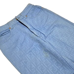May include: Light blue denim jeans with a subtle patterned design. The jeans have a classic five-pocket style.