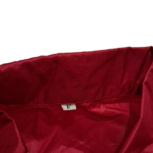 Peut inclure: Une veste rouge avec une &eacute;tiquette blanche sur laquelle est inscrit "F".