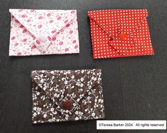 Poppered fabric purses.  Beautiful detail on front, two pockets inside.  Easily fits credit cards, business cards, and folded notes