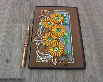 Hand decorated crystal art soft covered notebook with a spray of beautiful yellow flowers on it