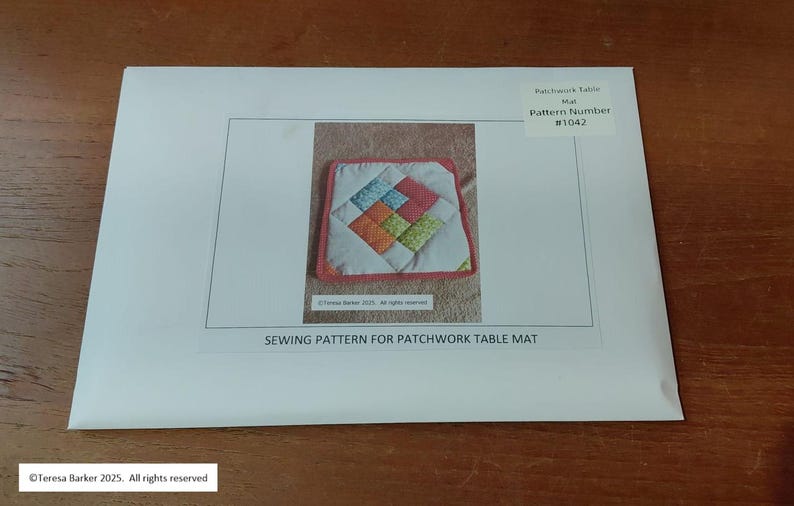 Może przedstawiać: Wz&oacute;r szycia na patchworkową matę na st&oacute;ł. Obraz przedstawia białą kopertę ze zdjęciem kolorowej pikowanej maty na st&oacute;ł. Tekst na kopercie brzmi "SEWING PATTERN FOR PATCHWORK TABLE MAT" i "Pattern Number #1042".