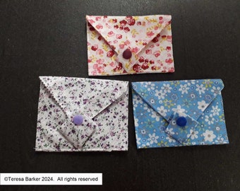 Poppered fabric purses.  Beautiful detail on front, two pockets inside.  Easily fits credit cards, business cards, and folded notes