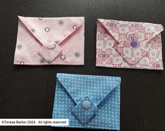 Poppered fabric purses.  Beautiful detail on front, two pockets inside.  Easily fits credit cards, business cards, and folded notes