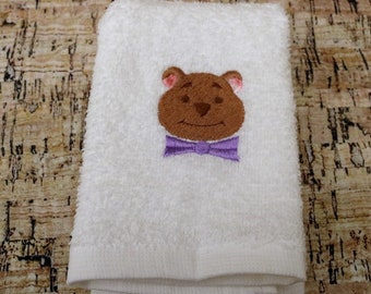 Machine embroidered face flannel with a teddy head on it.