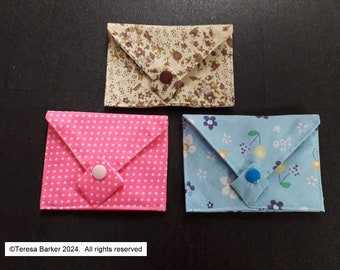 Poppered fabric purses.  Beautiful detail on front, two pockets inside.  Easily fits credit cards, business cards, and folded notes