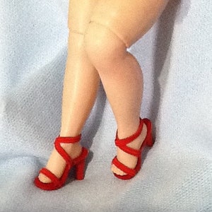 May include: A pair of red strappy heeled sandals with a criss-cross design.