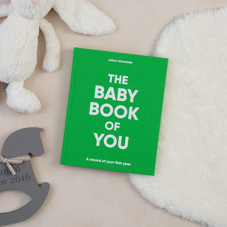 Celebrate the arrival of a baby with this inclusive baby record journal, a perfect baby shower gift for all families. Baby memory journal shown in green cloth covered hard backed book, new baby gift.