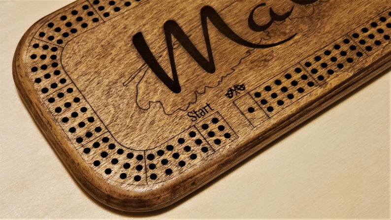 May include: A wooden game board with the word "Start" and a track for playing a game. The board is personalised with the name "Max".