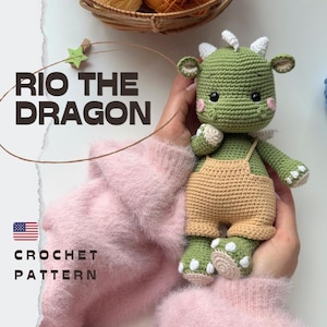Puede incluir: Un juguete de dragón tejido a ganchillo de color verde llamado Rio the Dragon que lleva un peto de color tostado. El dragón tiene cuernos blancos, mejillas rosadas y detalles blancos en los pies. El texto RIO THE DRAGON y CROCHET PATTERN es visible.