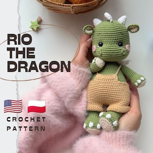 Puede incluir: Un juguete de dragón tejido a ganchillo de color verde llamado Rio the Dragon que lleva un peto color canela. El dragón tiene cuernos blancos, mejillas rosadas y ojos negros. El texto RIO THE DRAGON y CROCHET PATTERN es visible con banderas.
