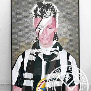 May include: A framed art print featuring a stylized portrait of a person with white hair and a lightning bolt across their face. They are wearing a black and white striped scarf and shirt with a Newcastle United badge.