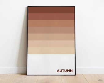 May include: A rectangular wall art print in a thin black frame featuring a vertical gradient of horizontal stripes transitioning from dark brown at the top to light beige at the bottom, with the word AUTUMN printed in brown at the bottom right.