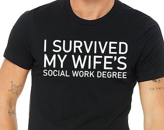 May include: A black t-shirt with white text that reads "I survived my wife's social work degree."