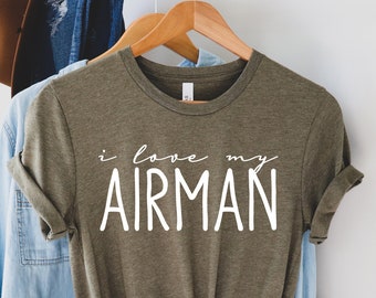 Könnte beinhalten: Ein grünes T-Shirt mit dem Text "i love my AIRMAN" in weißen Buchstaben.
