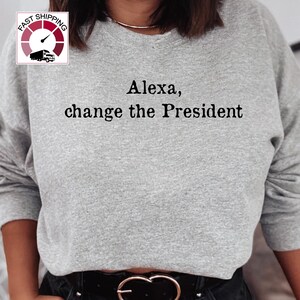 May include: Gray sweatshirt with the text "Alexa, change the President" printed on the front.