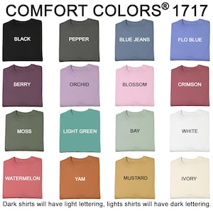 May include: A grid of t-shirts in various colors, including black, pepper, blue jeans, and flo blue. Each shirt displays its color name in contrasting lettering. The text "COMFORT COLORS&reg; 1717" is at the top, with a note about lettering.