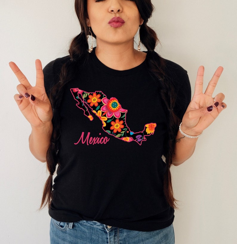 May include: Black t-shirt featuring a floral design of the outline of Mexico. The text "Mexico" is written in pink below the design.