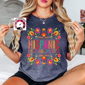 May include: A dark gray t-shirt with a colorful floral design and the text "HISPANIC HERITAGE MONTH".