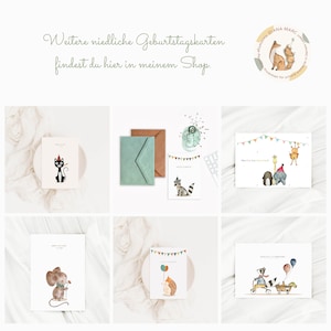 May include: Six different birthday cards featuring cute animal illustrations. The cards are on a white background with a light brown surface. The cards feature a cat, a raccoon, a giraffe, an elephant, a mouse, and a hedgehog.