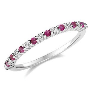 May include: A delicate silver band ring with alternating ruby and diamond stones.