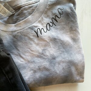 May include: A gray tie-dye t-shirt with the word "mama" written in black cursive on the front.