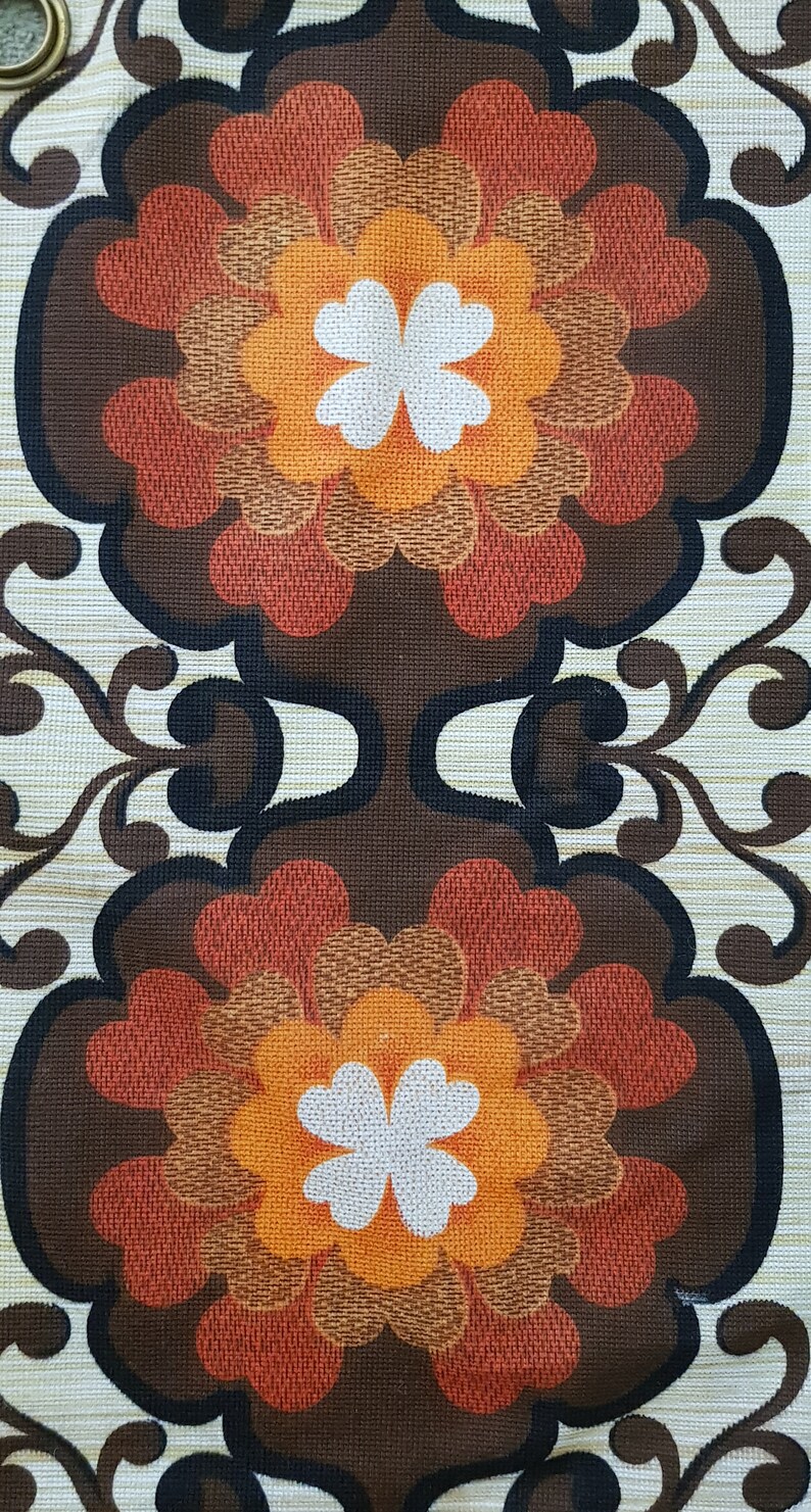 May include: A vintage fabric with a repeating pattern of brown, orange, and red flowers with white centers. The background is a light beige with a subtle texture.