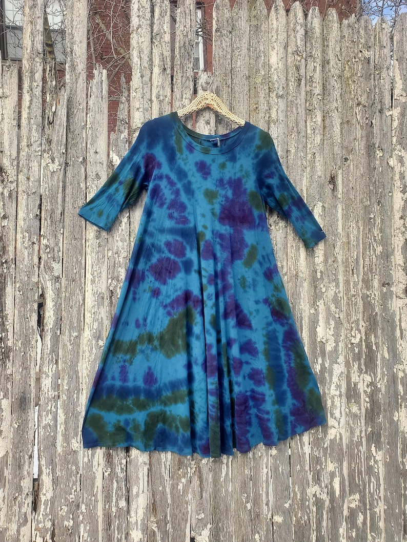 Dark Tie Dye Flowy Midi Dress, Greens and Purple, pinned on a wooden fence
