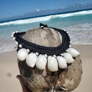 Colar statement extra grande com conchas lunares, feito em crochê com cordão preto.