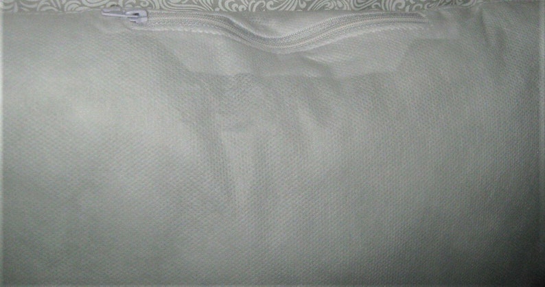 May include: A white zippered pouch made of a soft, textured fabric. The pouch is empty and appears to be made of a breathable material.