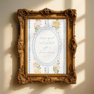 Op de afbeelding: Een ingelijste print met een sierlijke gouden lijst. De print toont de tekst "Every good and perfect gift is from above" in een ovaal, omringd door roze en gele bloemmotieven. De lijst is gedetailleerd.
